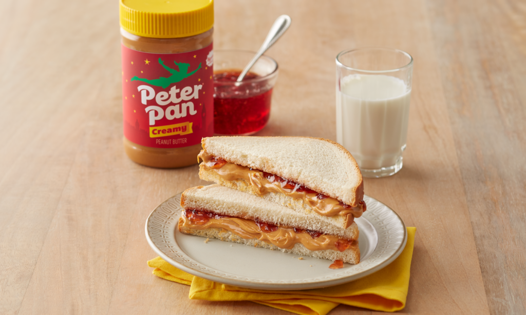 Peter Pan Regular Creamy Peanut Butter served on a peanut butter and jelly sandwich